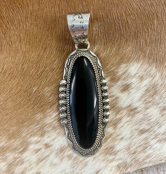 The perfect single stone sterling silver Native American made large onyx pendant to add to any necklace. This piece will look especially gorgeous on a strand of Navajo pearls. Stamped sterling and signed PY by Native artist silversmith Phillip Yazzie.    Size: 2.5” inch length + bale .75” inch   Signed: YES "PY"   Hallmark/ Artist: Phillip Yazzie  Stone: Onyx Large Black Onyx Pendant Handmade By Native American Phillip Yazzie