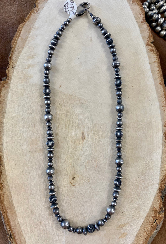 The Mixed Sized Navajo Pearl Necklace - Ny Texas Style Boutique Authentic sterling silver Navajo Pearl mixed size peal beaded 18” necklace. This particular necklace is stamped on the clasp. Take a look at the photos listed here on the listing to see. This is a beautiful staple piece that can be worn layered with other necklaces and pendants or alone. It’s simple yet elegant look makes it easy to pair with almost anything!