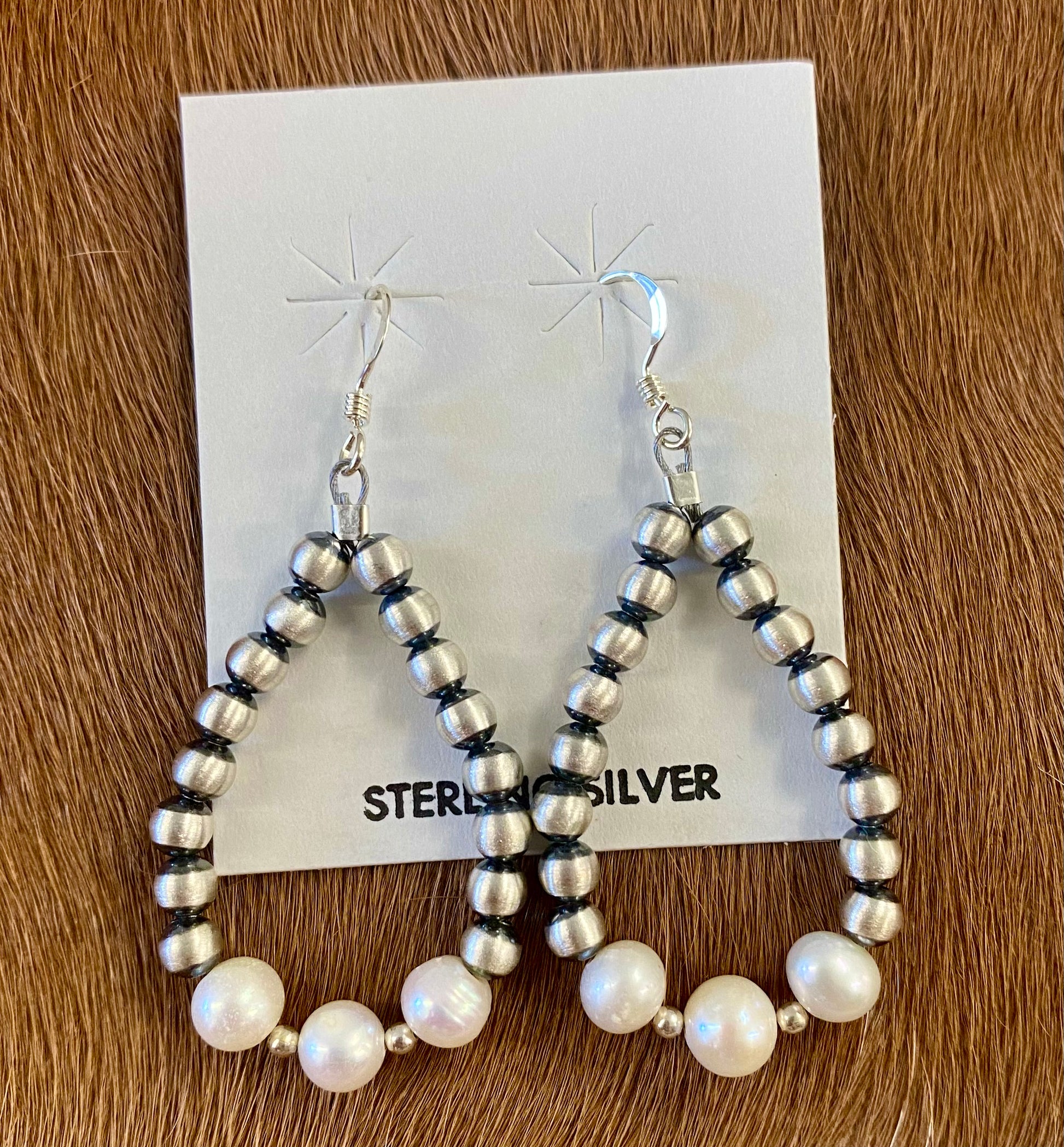 ﻿Gorgeous lightweight hand strung navajo pearl teardrop sterling silver earrings with white beads. The perfect earrings to add to anyone's jewelry collection. These Navajo pearl style teardrop earrings are hand strung together. Each of the sterling components are soldered closed to ensure durability and peace of mind.  Size: 1.5” inches length x 1” inch width 