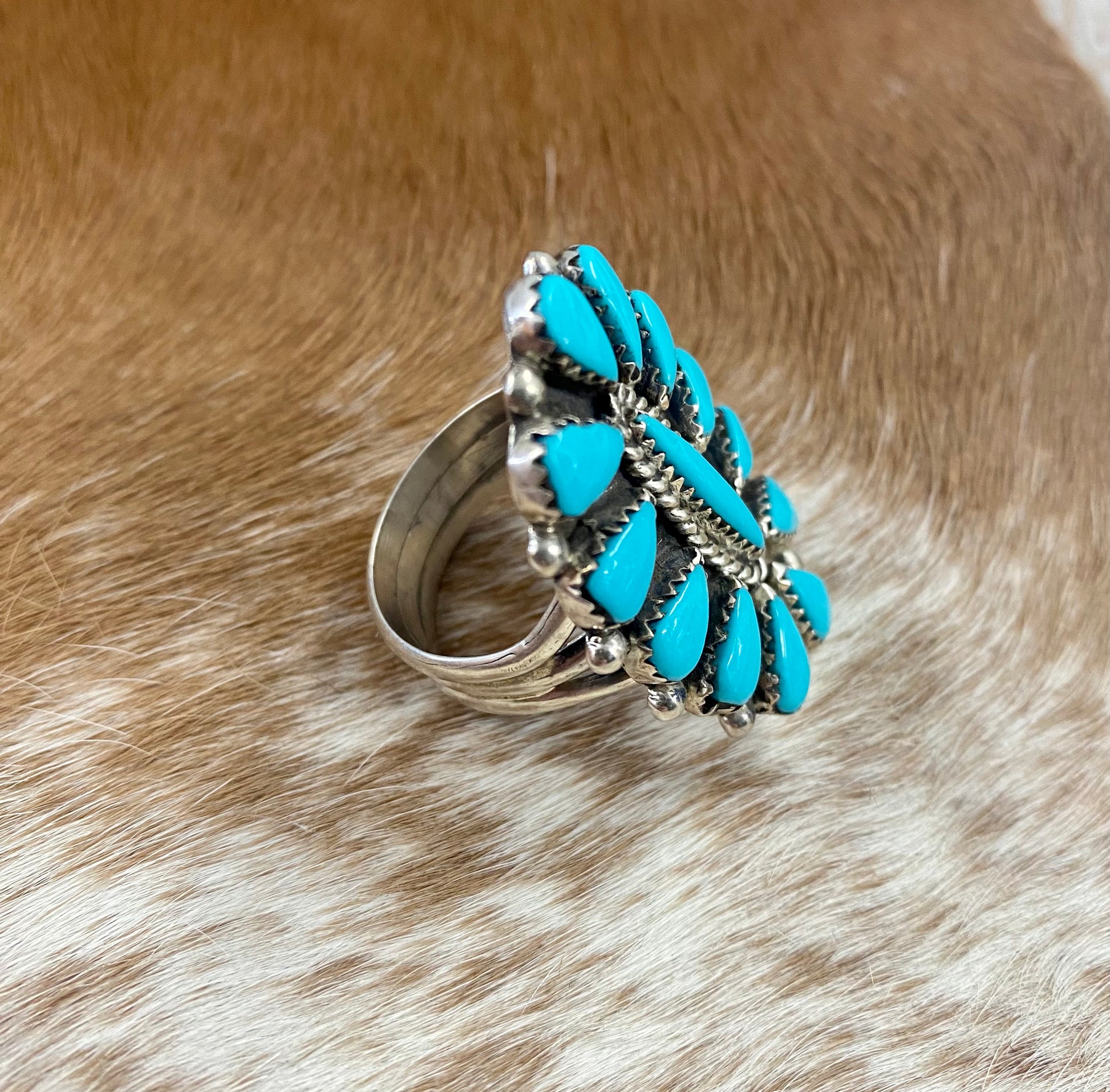 Sleeping Beauty turquoise traditional cluster sterling silver ring. Stamped sterling and signed on the back by a Zuni Native American artist silversmith. Available in size 12 1/2. The perfect piece to add to your accessory wardrobe and jewelry collection.   Size: 1.5 Inches Length X 1” Inch Width    Stone: Sleeping Beauty Turquoise   Signed: YES 