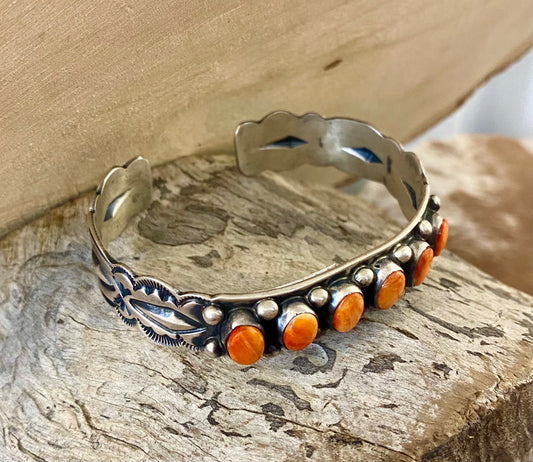 Aldine Orange Spiny Oyster Sterling Silver Cuff | Native Made Jewelry Stunning sterling silver native made stamped six stone orange spiny oyster cuff. Stamped sterling and signed on the inside of the cuff with the initial L by artist silversmith. Please see photos above for exact hallmark. This piece is gorgeous from every angle and will make a statement with any outfit.