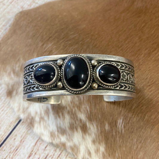 Triple Stone Handmade Native Made Black Onyx Cuff Bracelet Signed JASterling silver three stone black Onyx cuff with stamped detailing throughout the cuff. Stamped sterling and signed JA on the inside of the cuff, see photos for exact hallmark/artist stamp. This onyx cuff is so classic and will easily become one of your favorite accessories! Size: 6.5” Inch length of the cuff (not including gap) | .8” of an inch thick Signed: YES "JA" Stone: Onyx