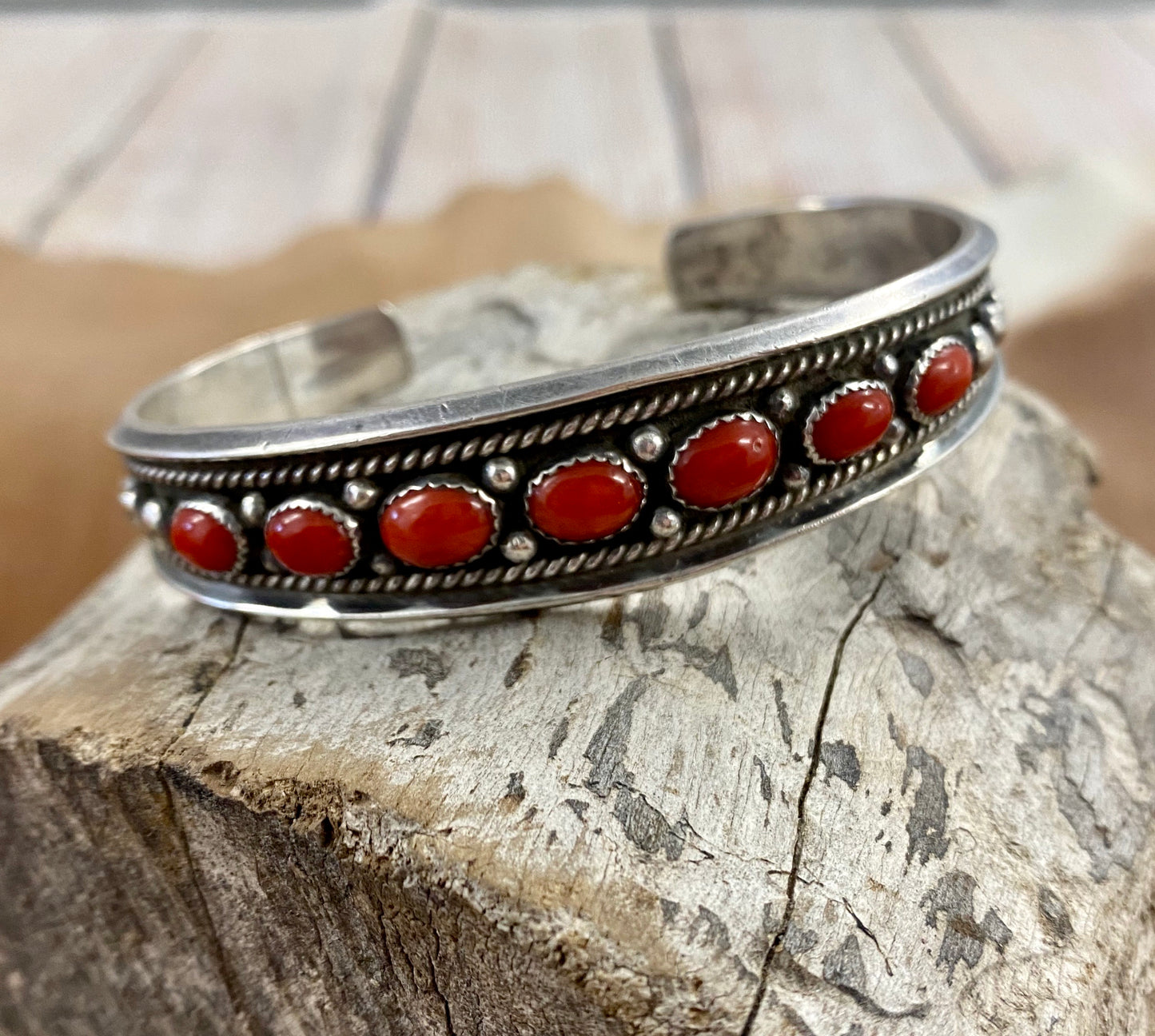 The Red River Handmade Coral Sterling Silver Cuff Bracelet  Authentic sterling silver seven coral stones thin cuff. The perfect pop of color to add to your jewelry collection! This piece is stunning and is perfect to layer with other bracelets or cuffs or to wear alone. Coral wraps the cuff giving you the perfect pieces of red coral from every angle. 
