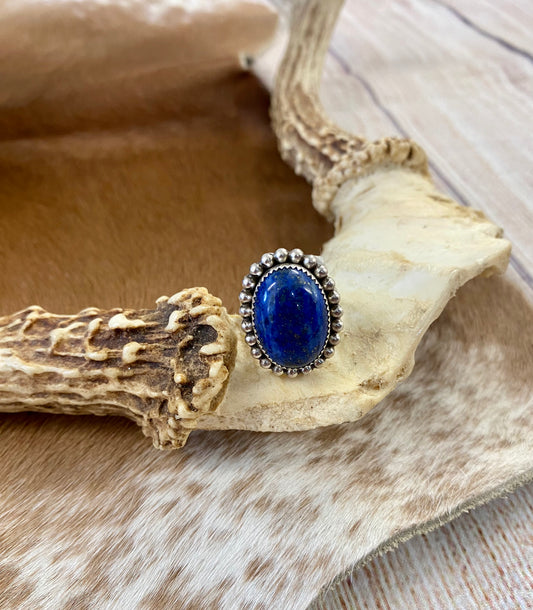 Beautiful single stone simple yet striking sterling silver blue lapis round size 7 ring. This piece is stamped Sterling and signed B on the back by Native American artist silversmith. A gorgeous ring that will add a pop of color to any outfit. Signed: YES “B” Ring Size: 7 Size: 1” inch length Stone: Blue Lapis