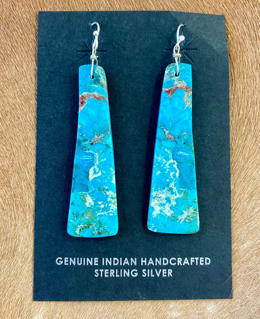 Gorgeous unique large turquoise slab sterling silver Native American made earrings. Beautiful statement handmade earrings, perfect for so many different occasions. From weddings, NFR, to everyday wear! Size: 2” inch length Stone: Turquoise Native American Made Sterling Silver Large Turquoise Slab Earrings