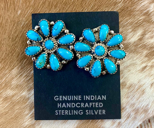 Beautiful sterling silver simple and fun Native made turquoise post cluster earrings. These earrings are stamped sterling and signed on the back by Native American artist silversmith. The perfect everyday or dress up earrings! Size: 1” inch length x 1” inch width Signed: YES "OM" Stone: Turquoise