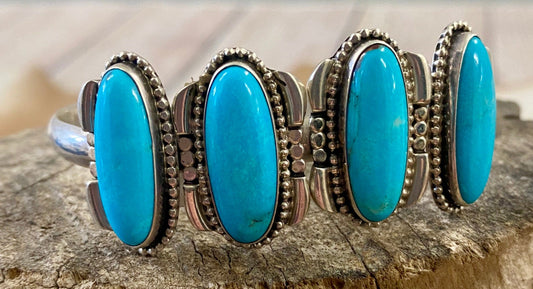 Silver four stone Native American made turquoise stamped sterling and signed cuff. This cuff is absolutely stunning and the perfect piece for your jewelry collection or give as a gift to a loved one. Stamped Sterling & Signed R.B. Inside of a bear icon for Running Bear Shop on the inside of the cuff. Size: Stones are 1” length 6.5” all the way around not including gap Stone: Turquoise Signed: YES "R.B." Inside of a bear icon Hallmark/Artist: Running Bear Shop