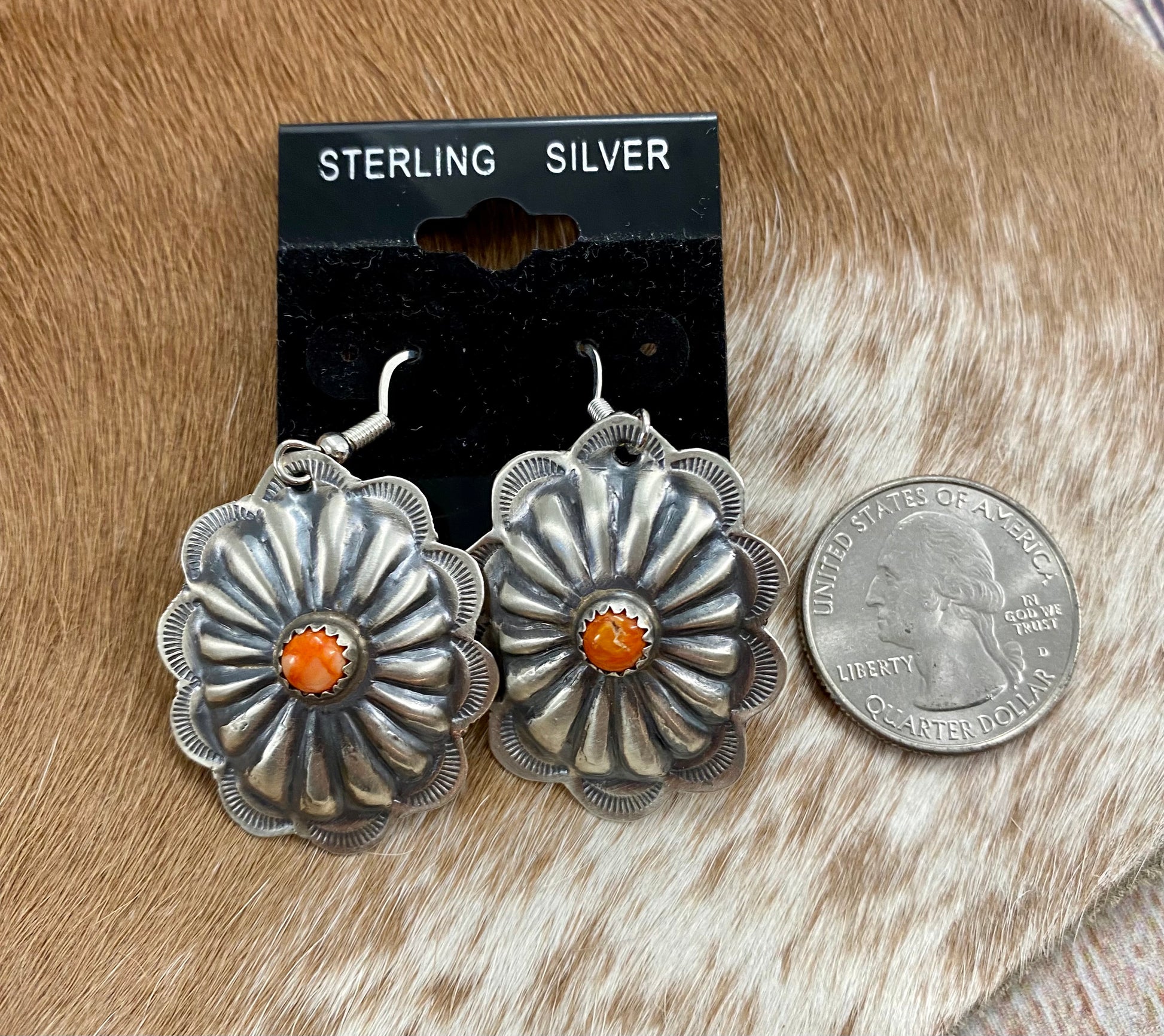 earrings placed next to quarter