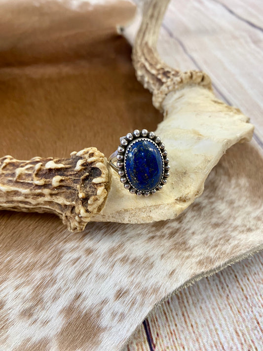 Beautiful single stone simple yet striking sterling silver blue denim lapis round size 9 ring. This piece is stamped Sterling and signed B by a Native American artist silversmith. A gorgeous shade of blue ring that will add a pop of color to any outfit. Signed: YES “B” Ring Size: 9 Size: 1” inch length Stone: Blue Lapis