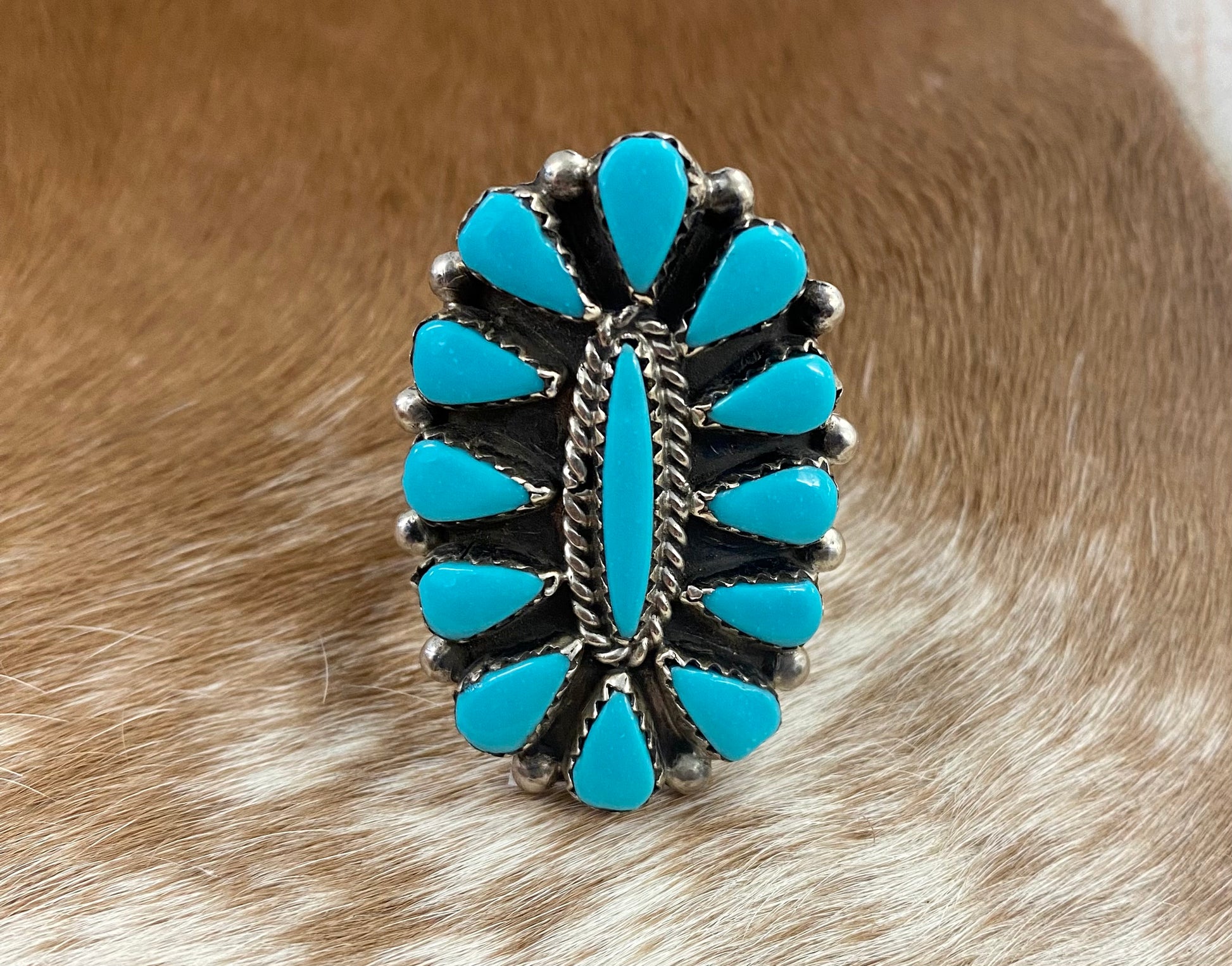 Sleeping Beauty turquoise traditional cluster sterling silver ring. Stamped sterling and signed on the back by a Zuni Native American artist silversmith. Available in size 12 1/2. The perfect piece to add to your accessory wardrobe and jewelry collection.   Size: 1.5 Inches Length X 1” Inch Width    Stone: Sleeping Beauty Turquoise   Signed: YES 